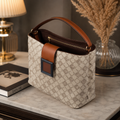 Beige monogram bucket bag side angle on marble