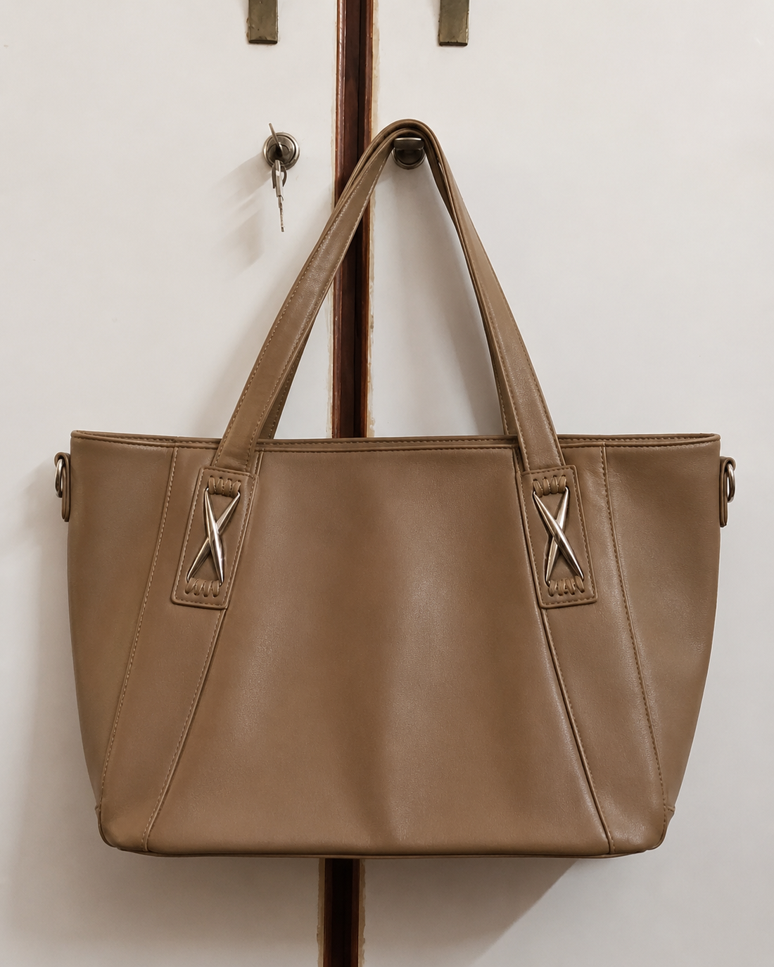 Mocha leather mega tote bag hanging on rack