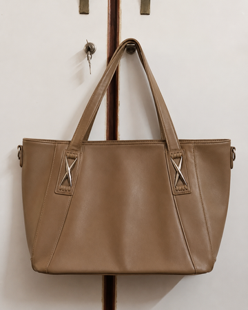 Mocha leather mega tote bag hanging on rack
